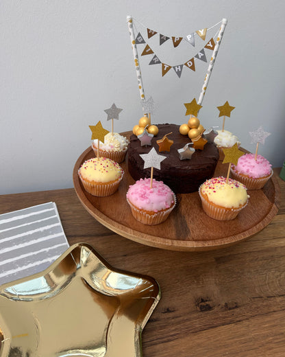 Decorative tray with cupcakes, stars, and a small flag on a wooden surface.